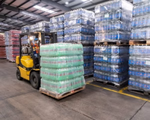 Cariste déplaçant une palette de boissons avec un chariot élévateur Yale dans un entrepôt logistique.